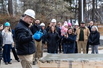 BIW President Charles F. Krugh gives a thumbs up sign after adding his handprints to the cement slab that will become part of the new childcare facility’s bicycle rack.