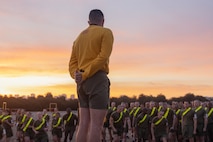 U.S. Marine Corps Chief Drill Instructor, Staff Sgt. Sal Bustamante with Echo Company, 2nd Recruit Training Battalion, conducts warm-ups before the running portion of a physical fitness test at Marine Corps Recruit Depot San Diego, California, Dec. 16, 2024. The PFT is an evaluation that all recruits must pass and sets the standards all Marines must maintain once a year to assess battle readiness as well as physical conditioning. The Marine Corps is a professional, disciplined, and capable force. Honor, courage, and commitment are seen and felt in the shared experiences, hardships and challenges we face together in training, and in combat. These values embody what it is to be a Marine, and they live in the collective soul of our Corps. (U.S. Marine Corps photo by Lance Cpl. Janell B. Alvarez)