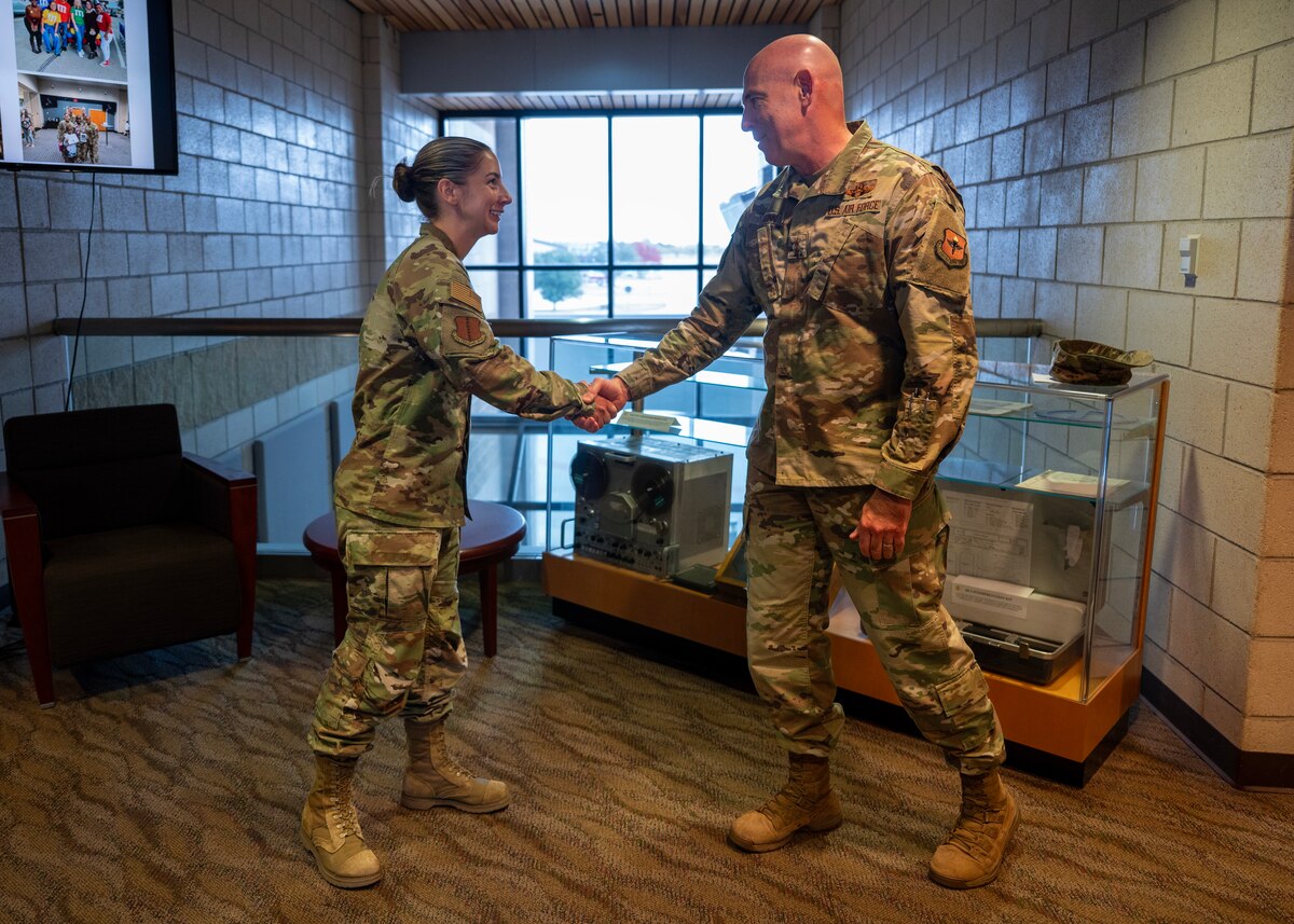 U.S. Air Force Maj. Gen. Clerk Quinn, Air Education and Training Command deputy commander, coins Capt. Michelle Leigh, 17th Training Wing judge advocate, during a visit to Goodfellow Air Force Base, Texas, Dec. 17, 2024. Quinn engaged with Airmen across the base, commending them for their dedication to mission success and readiness, emphasizing that everyone plays a vital role in preparing the Air Force for the next fight. (U.S. Air Force photo by Senior Airman Sarah Williams)