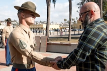 Baby Aisla’s grandpa, pins U.S. Marine Corps Drill Instructor, Staff Sgt. Barry Clayton, left, with Charlie Company, 1st Recruit Training Battalion, who is being presented with a Navy and Marine Corps Achievement Medal at Marine Corps Recruit Depot San Diego, California, Dec. 13, 2024. A NAM is given to members of the U.S. Navy and Marine Corps for meritorious service or achievement. Delacruz and Clayton received a NAM for exemplifying unrivaled courage and extraordinary presence of mind when confronting a life-threatening emergency. The words “drill instructor, drill instructor, drill instructor” were called and Delacruz and Clayton sprang into action to save a fourteen-month-old infant who was unconscious and not breathing. Providing CPR and proper throat sweeping techniques they successfully dislodged the obstruction and the infant regained consciousness. Likely saving baby Aisla’s life.  The family of the infant was onsite during the ceremony and presented the awards. The Marine Corps has served the Nation honorably for 250 years. Marines embody the uncompromising standards and characteristics of honor, courage and commitment.