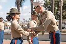 U.S. Marine Corps Drill Instructor, Staff Sgt. Burruel Delacruz with Charlie Company, 1st Recruit Training Battalion, is presented with a Navy and Marine Corps Achievement Medal from Commanding Officer of 1st Recruit Training Battalion, Lt. Col. Roger Hollenbeck, Marine Corps Recruit Depot San Diego at MCRD San Diego, California, Dec. 13, 2024. A NAM is given to members of the U.S. Navy and Marine Corps for meritorious service or achievement. Delacruz and Clayton received a NAM for exemplifying unrivaled courage and extraordinary presence of mind when confronting a life-threatening emergency. The words “drill instructor, drill instructor, drill instructor” were called and Delacruz and Clayton sprang into action to save a fourteen-month-old infant who was unconscious and not breathing. Providing CPR and proper throat sweeping techniques they successfully dislodged the obstruction and the infant regained consciousness. Likely saving baby Aisla’s life.  The family of the infant was onsite during the ceremony and presented the awards. The Marine Corps has served the Nation honorably for 250 years. Marines embody the uncompromising standards and characteristics of honor, courage and commitment.