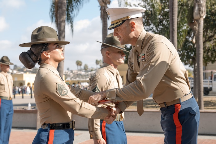 U.S. Marine Corps Drill Instructor, Staff Sgt. Burruel Delacruz with Charlie Company, 1st Recruit Training Battalion, is presented with a Navy and Marine Corps Achievement Medal from Commanding Officer of 1st Recruit Training Battalion, Lt. Col. Roger Hollenbeck, Marine Corps Recruit Depot San Diego at MCRD San Diego, California, Dec. 13, 2024. A NAM is given to members of the U.S. Navy and Marine Corps for meritorious service or achievement. Delacruz and Clayton received a NAM for exemplifying unrivaled courage and extraordinary presence of mind when confronting a life-threatening emergency. The words “drill instructor, drill instructor, drill instructor” were called and Delacruz and Clayton sprang into action to save a fourteen-month-old infant who was unconscious and not breathing. Providing CPR and proper throat sweeping techniques they successfully dislodged the obstruction and the infant regained consciousness. Likely saving baby Aisla’s life.  The family of the infant was onsite during the ceremony and presented the awards. The Marine Corps has served the Nation honorably for 250 years. Marines embody the uncompromising standards and characteristics of honor, courage and commitment.