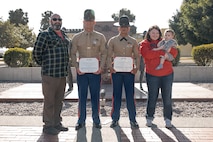The family of baby Aisla and U.S. Marine Corps Drill Instructors, Staff Sgt. Burruel Delacruz, front left, and Staff Sgt. Barry Clayton, back left, both with Charlie Company, 1st Recruit Training Battalion, pose for a photo after being presented a Navy and Marine Corps Achievement Medal at Marine Corps Recruit Depot San Diego, California, Dec. 13, 2024. A NAM is given to members of the U.S. Navy and Marine Corps for meritorious service or achievement. Delacruz and Clayton received a NAM for exemplifying unrivaled courage and extraordinary presence of mind when confronting a life-threatening emergency. The words “drill instructor, drill instructor, drill instructor” were called and Delacruz and Clayton sprang into action to save a fourteen-month-old infant who was unconscious and not breathing. Providing CPR and proper throat sweeping techniques they successfully dislodged the obstruction and the infant regained consciousness. Likely saving baby Aisla’s life.  The family of the infant was onsite during the ceremony and presented the awards. The Marine Corps has served the Nation honorably for 250 years. Marines embody the uncompromising standards and characteristics of honor, courage and commitment.