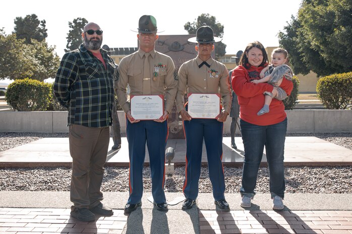 The family of baby Aisla and U.S. Marine Corps Drill Instructors, Staff Sgt. Burruel Delacruz, front left, and Staff Sgt. Barry Clayton, back left, both with Charlie Company, 1st Recruit Training Battalion, pose for a photo after being presented a Navy and Marine Corps Achievement Medal at Marine Corps Recruit Depot San Diego, California, Dec. 13, 2024. A NAM is given to members of the U.S. Navy and Marine Corps for meritorious service or achievement. Delacruz and Clayton received a NAM for exemplifying unrivaled courage and extraordinary presence of mind when confronting a life-threatening emergency. The words “drill instructor, drill instructor, drill instructor” were called and Delacruz and Clayton sprang into action to save a fourteen-month-old infant who was unconscious and not breathing. Providing CPR and proper throat sweeping techniques they successfully dislodged the obstruction and the infant regained consciousness. Likely saving baby Aisla’s life.  The family of the infant was onsite during the ceremony and presented the awards. The Marine Corps has served the Nation honorably for 250 years. Marines embody the uncompromising standards and characteristics of honor, courage and commitment.