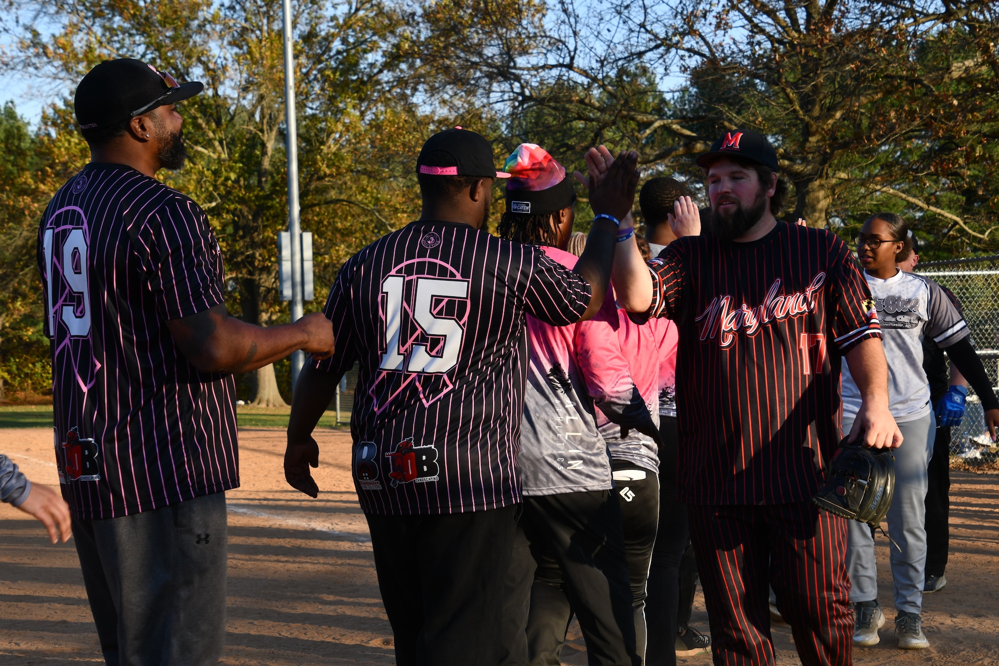 Players high-five after a softball game.