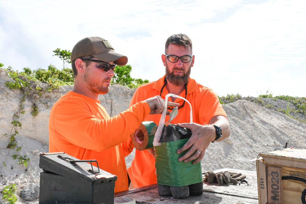 Contracted explosive ordnance disposal technicians secure four WWII-era Japanese 75mm Type 94 high-explosive projectiles