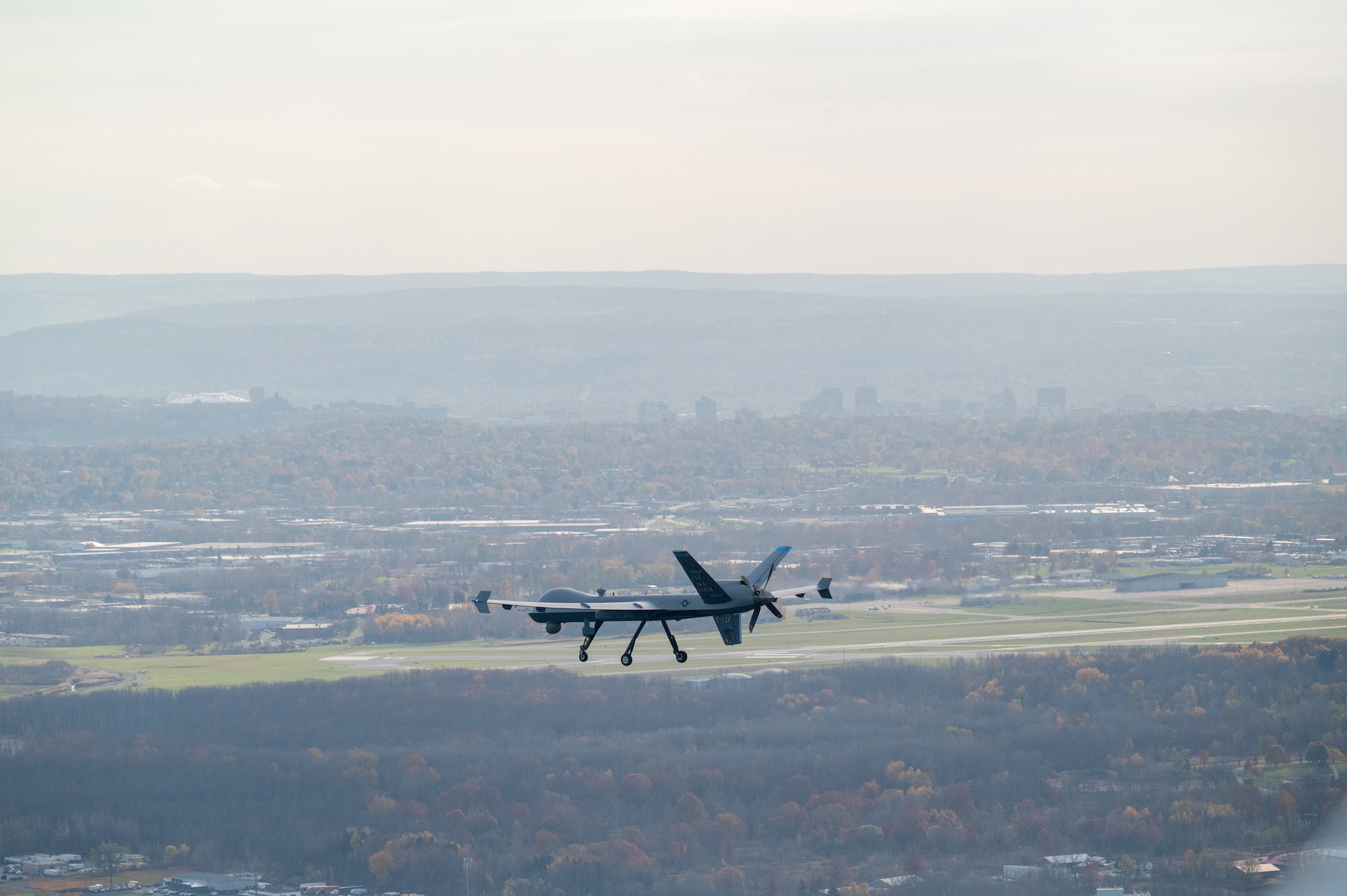 A MQ-9 Reaper assigned to the 174th Attack Wing flies over Hancock Field Air National Guard Base, Syracuse, NY, during a routine training flight, Oct. 31, 2024. The 108th Attack Squadron conducts training flights to instruct pilots and sensor operators on proper operations of the aircraft. (U.S. Air National Guard photo by Senior Airman Dylan McCrink)