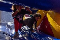 Participants run on an inflated obstacle course during a Devil Pups event at Marine Corps Recruit Depot San Diego, California, Dec. 14, 2024. The Devil Pups event is held in order to allow participants, aged five to twelve-years-old, to learn about Marine Corps culture, history, and traditions. This program is also a part of the Lifestyle, Insight, Network, Knowledge, and Skills Program, an interactive acculturation program to the Marine Corps lifestyle. (U.S. Marine Corps photo by Lance Cpl. Jacob B. Hutchinson)