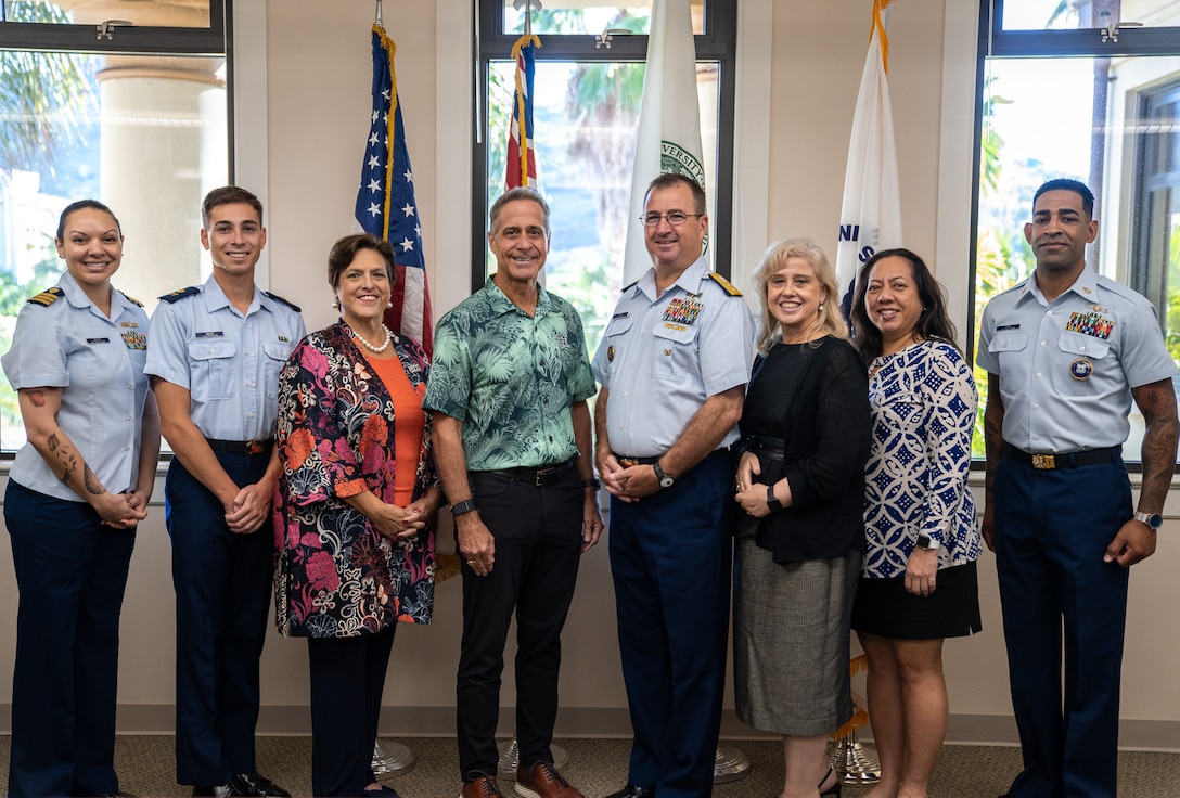 Coast Guard Rear Adm. Sean Regan, commander of District Fourteen, and Michael Bruno, provost at the University of Hawai’i at Mānoa, pose for a photo with Coast Guard members and UH Mānoa staff after a ceremony at the campus in Honolulu, Hawaii, Dec. 19, 2024. During the ceremony, the Coast Guard and UH Mānoa signed an updated memorandum of agreement to continue the College Student Pre-Commissioning Initiative scholarship program at UH Mānoa. (U.S. Coast Guard photo by Petty Officer 2nd Class Tyler Robertson)