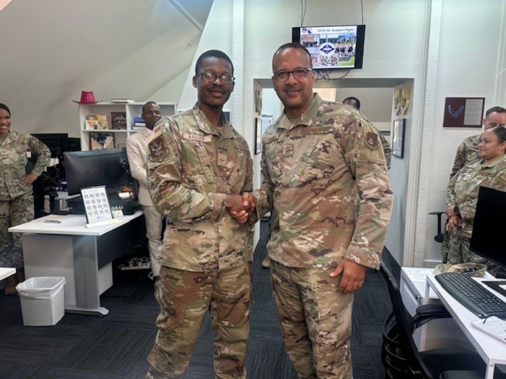 Chief Master Sgt. Kenneth Eason, Pacific Air Forces individual mobilization augmentee to the command chief, coins Senior Airman Lance Vasser, 337th Air Support Flight financial operations technician, at the U.S. Embassy in Canberra, Australia, Dec. 7-13, 2024. The 337th Air Support Flight is aligned under the 374th Airlift Wing out of Yokota Air Base, Japan, and the unit supports administrative functions for all U.S. military personnel assigned to Australia locations. (U.S. Air Force courtesy photo)