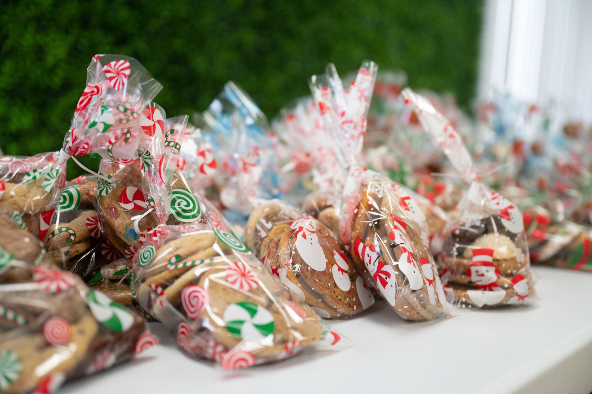cookies in holiday theme bags are resting on top of a table.