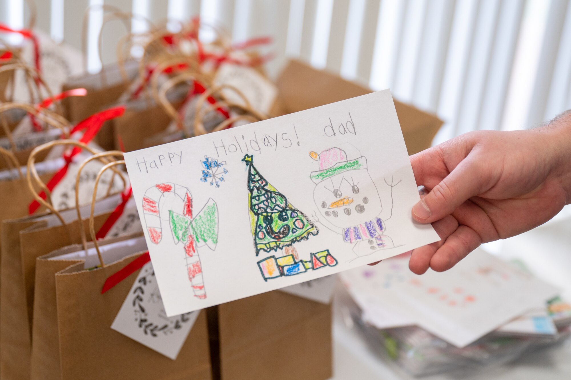 a Christmas card is being held by a hand.