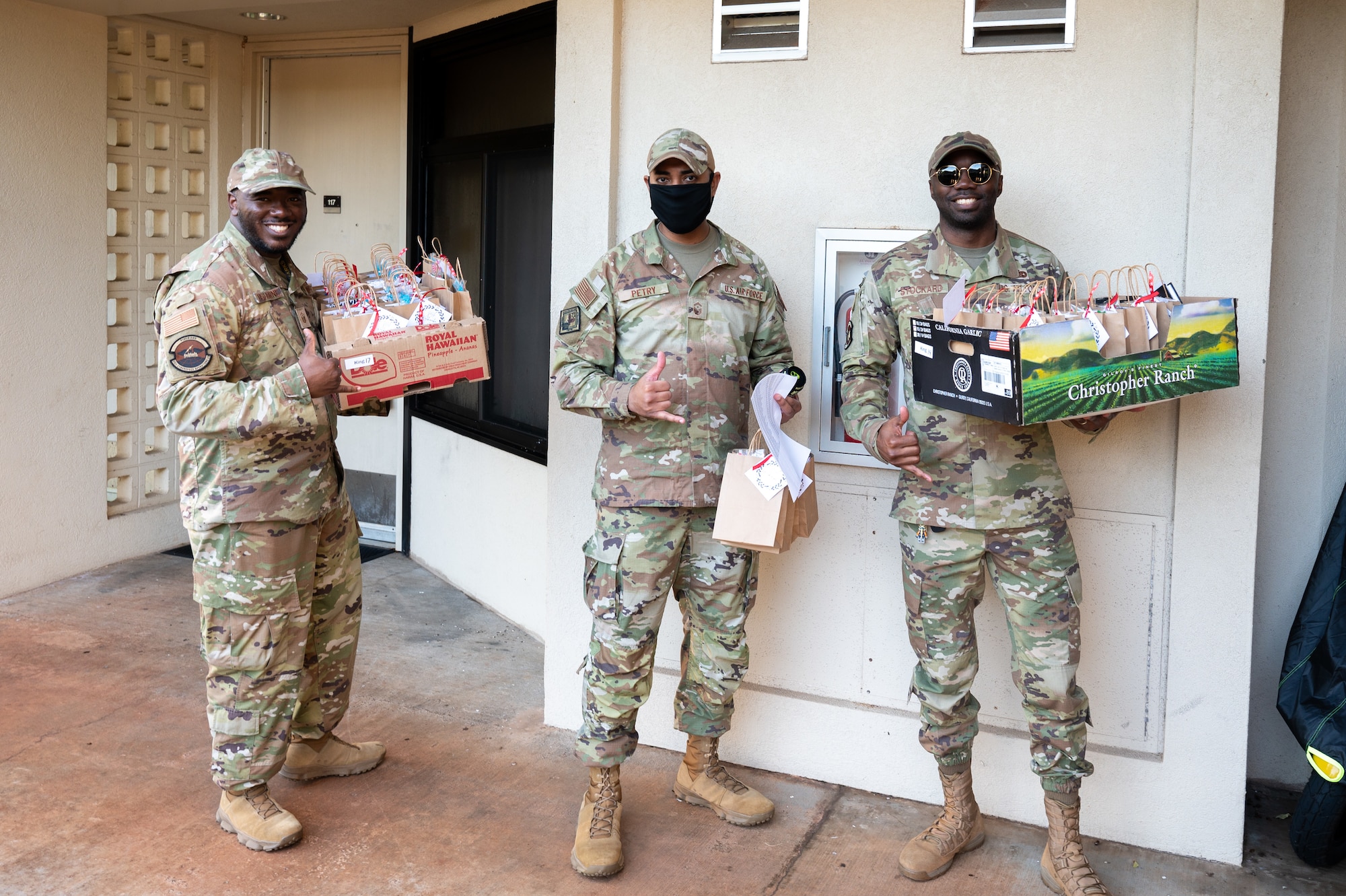 U.S. Air Force Airmen pose for a photo while handing out Holiday cookies to Airmen living in unaccompanied housing.