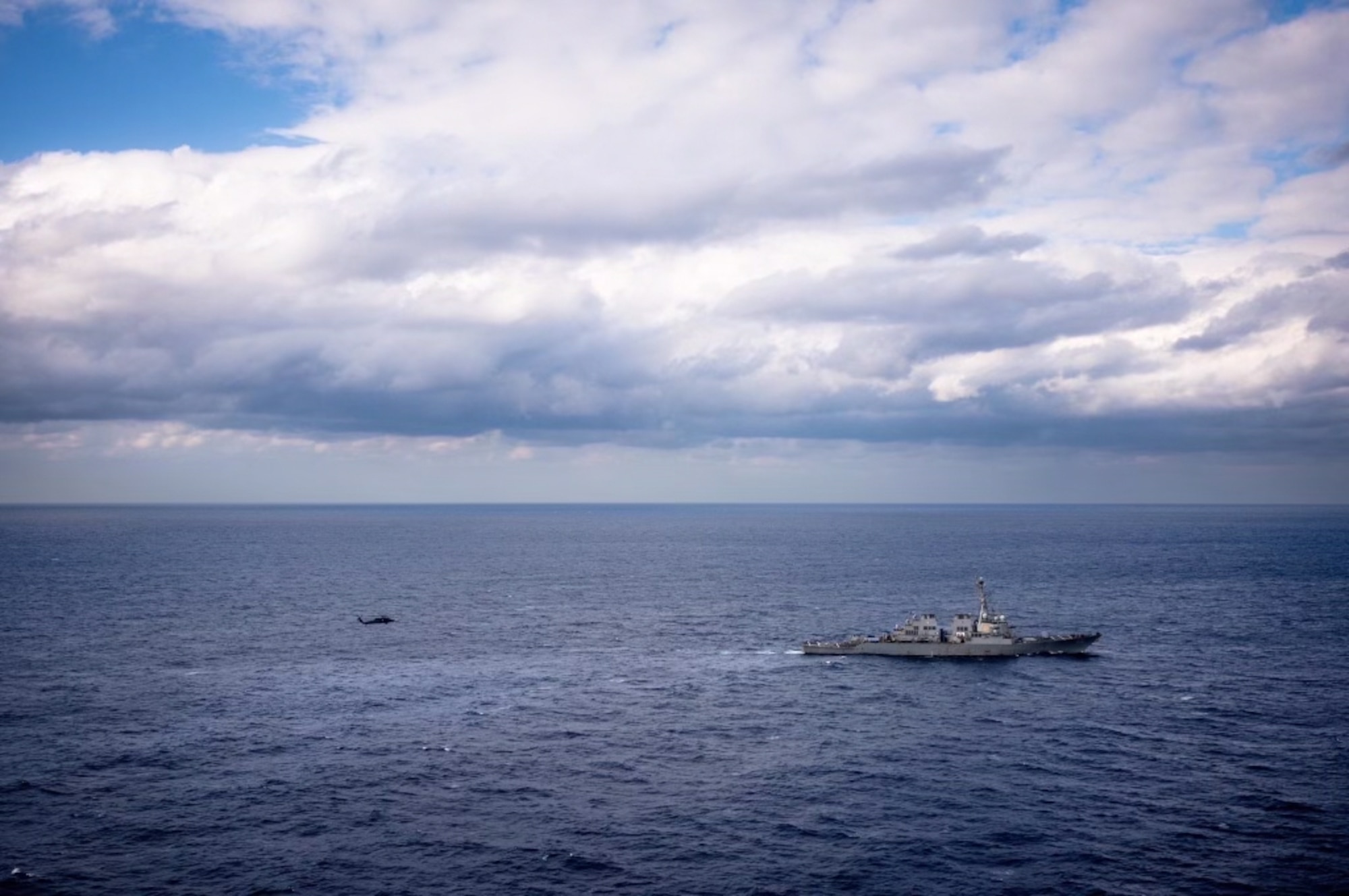 U.S. Air Force helicopter approaching U.S. Navy ship.