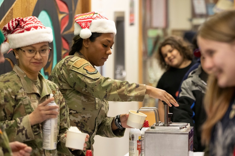 Alaska Air National Guard Master Sgt. Samantha Smith, assigned to the AKNG Joint Force Headquarters command support staff, serves ice cream to Yakutat children as part of Operation Santa Claus in Yakutat, Alaska, Dec. 18, 2024.