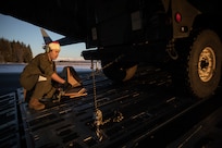 Alaska Air National Guard Airman 1st Class Trystan Costanios, a loadmaster assigned to the 144th Airlift Squadron, 176th Wing, secures an Alaska Army National Guard Humvee onto a C-17 Globemaster III in support of Operation Santa Claus at Yakutat, Alaska, Dec. 18, 2024.