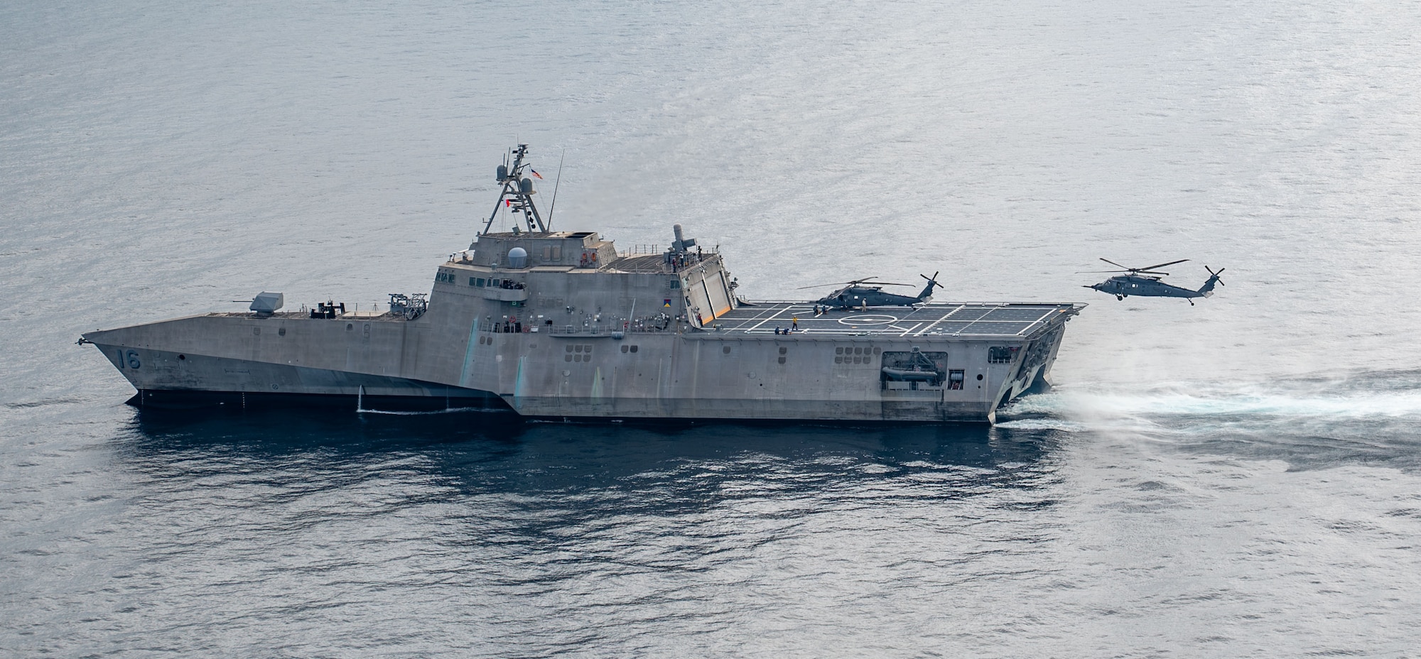A U.S. Air Force HH-60W Jolly Green II helicopter approaches littoral combat ship USS Tulsa (LCS 16)