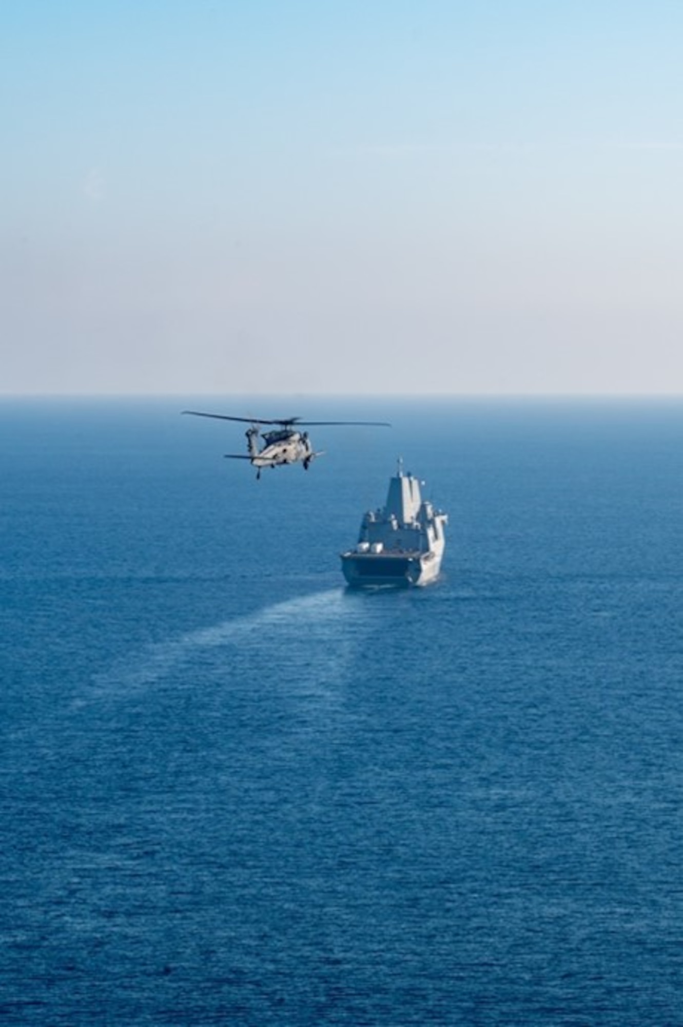 A U.S. Air Force HH-60W Jolly Green II helicopter assigned to the 943d Rescue Group approaches amphibious transport dock ship USS Somerset (LPD 25)