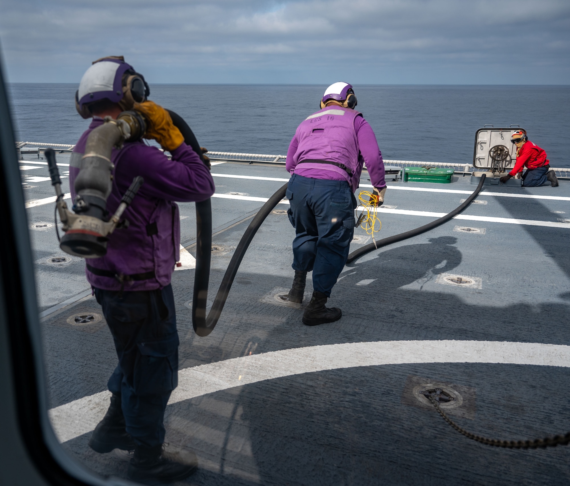 U.S. Navy Sailors remove the fuel tube from an HH-60W Jolly Green II helicopter