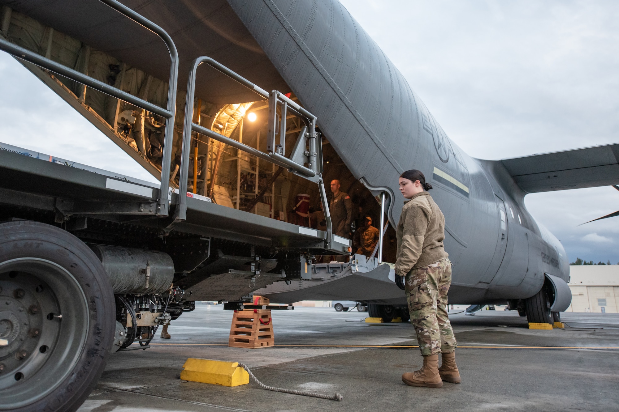Airman Basic Makenna Rollins, a supply specialist with the 123rd Airlift Wing, spots cargo being uploaded to a Kentucky Air National Guard C-130J Super Hercules aircraft in support of Operation Arctic Haven at Joint Base Elmendorf-Richardson, Alaska, Sept. 2, 2024. Thirty-six wing Airmen supported the Innovative Readiness Training mission, which airlifted 39 short tons of residential building supplies to two remote villages in northern Alaska. (U.S. Air National Guard photo by Tech. Sgt. Chloe Ochs)