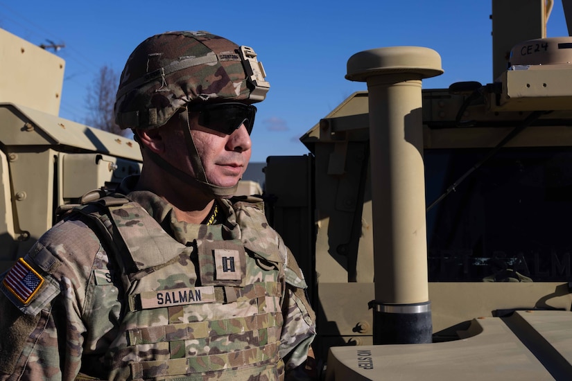 An Army captain stands outdoors in uniform.