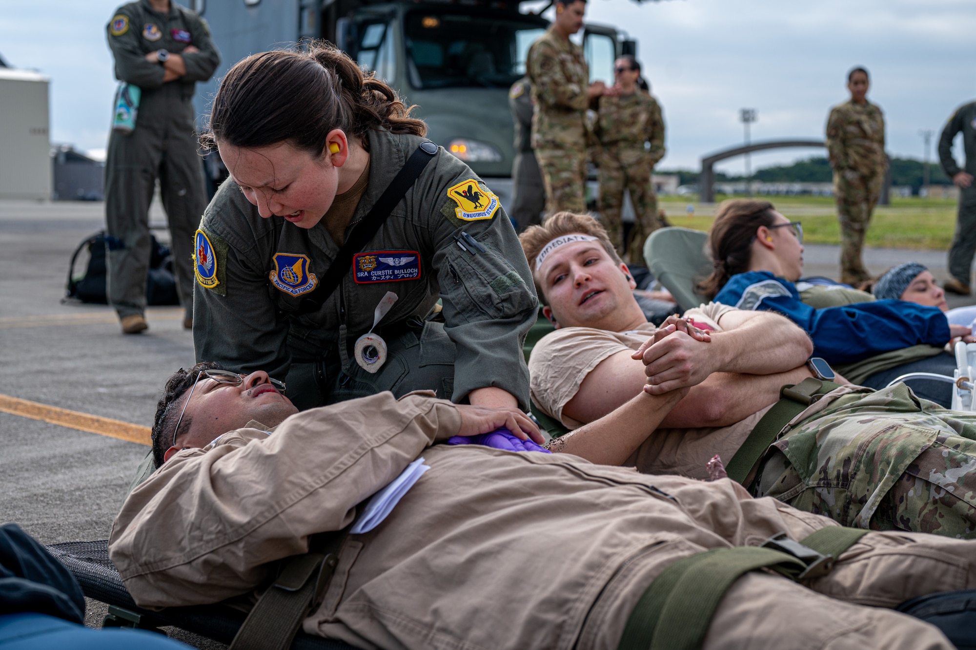 U.S. Air Force Senior Airman Curstie Bulloch, 18th Aeromedical Evacuation Squadron aeromedical evacuation technician, conducts a scenario for identifying simulated patients’ injuries during a patient transfer exercise with the Marine Aerial Refueler Transport Squadron 152 at Kadena Air Base, Japan, Dec. 18, 2024.