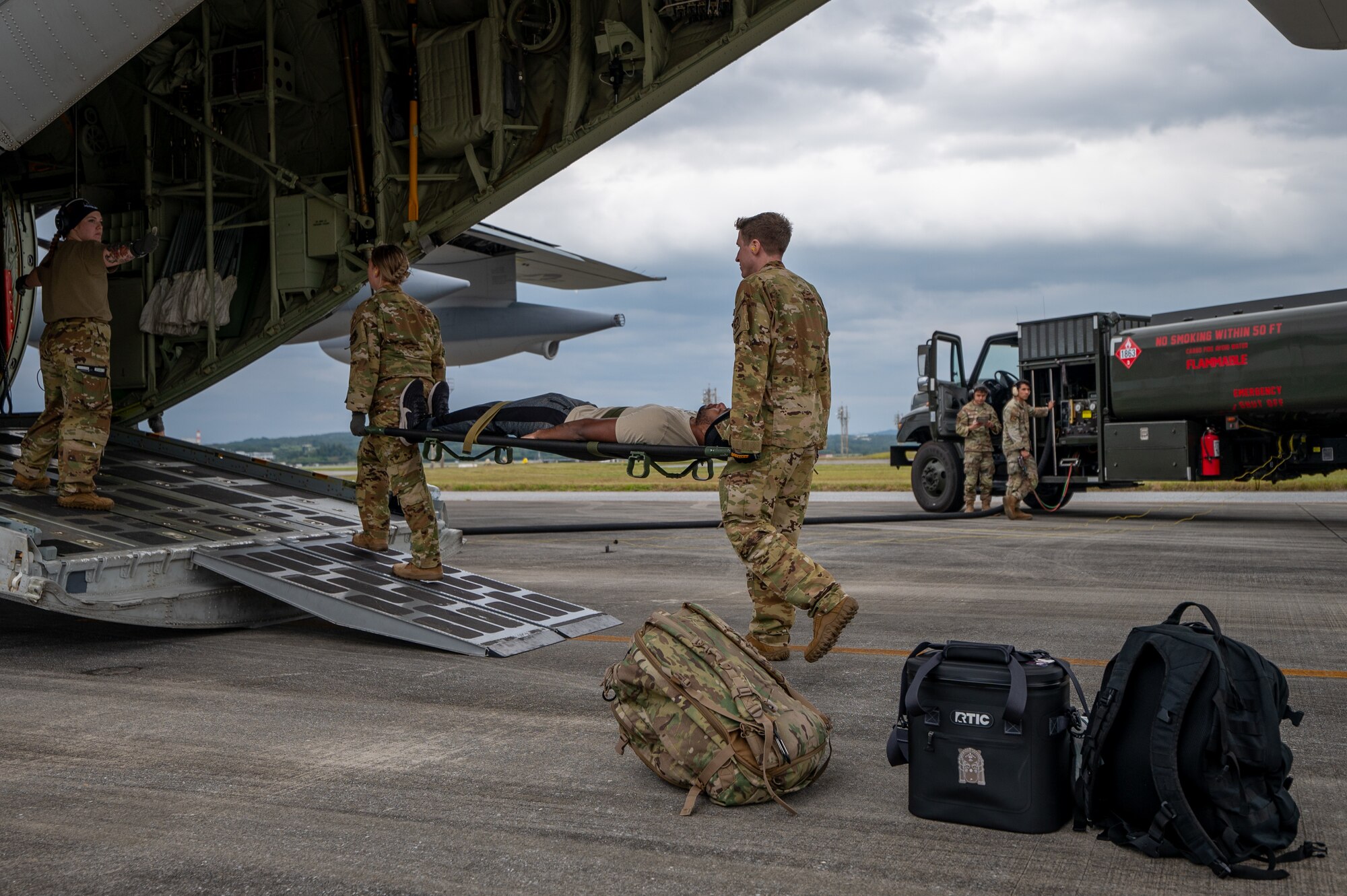 U.S. Air Force Airmen with the 18th Aeromedical Evacuation Squadron carry a simulated patient onto a KC-130J Hercules during a patient transfer exercise with the Marine Aerial Refueler Transport Squadron 152 at Kadena Air Base, Japan, Dec. 18, 2024.