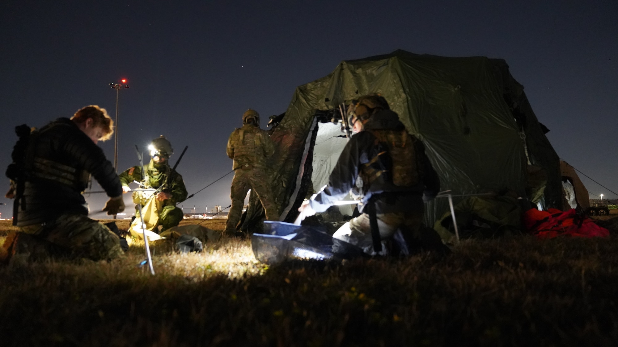 Airmen set up communications and tents on an airfield.