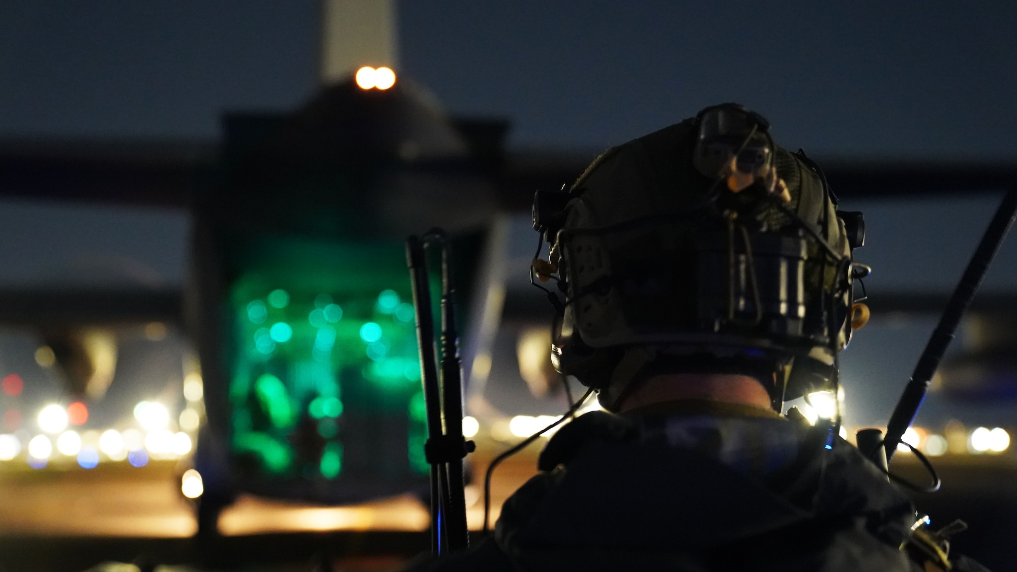 An Airman marshals a MC-130J on an airfield.