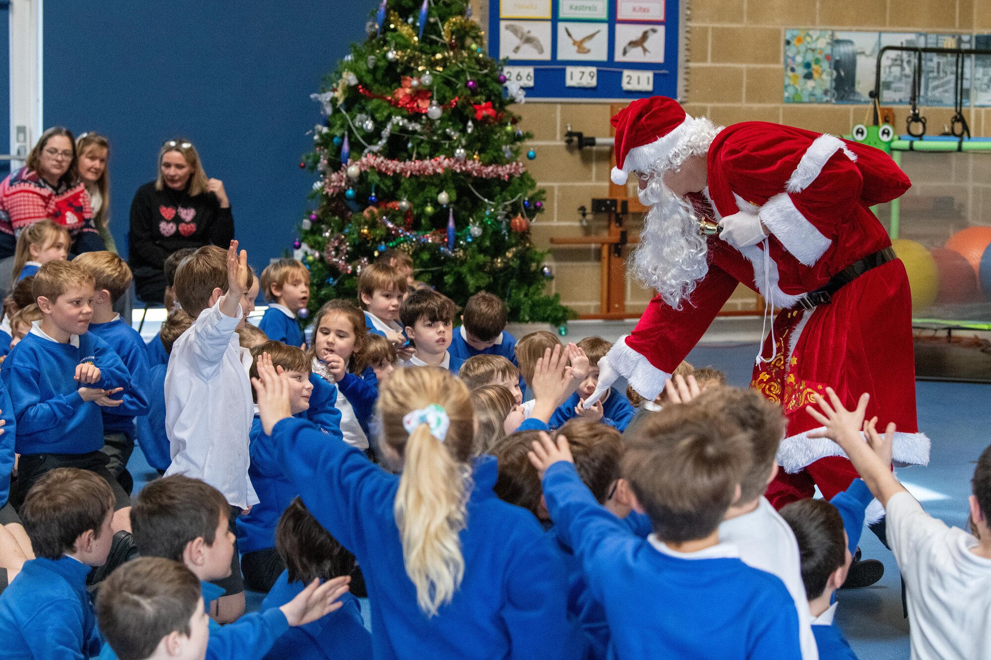 Santa Claus high-fives school children