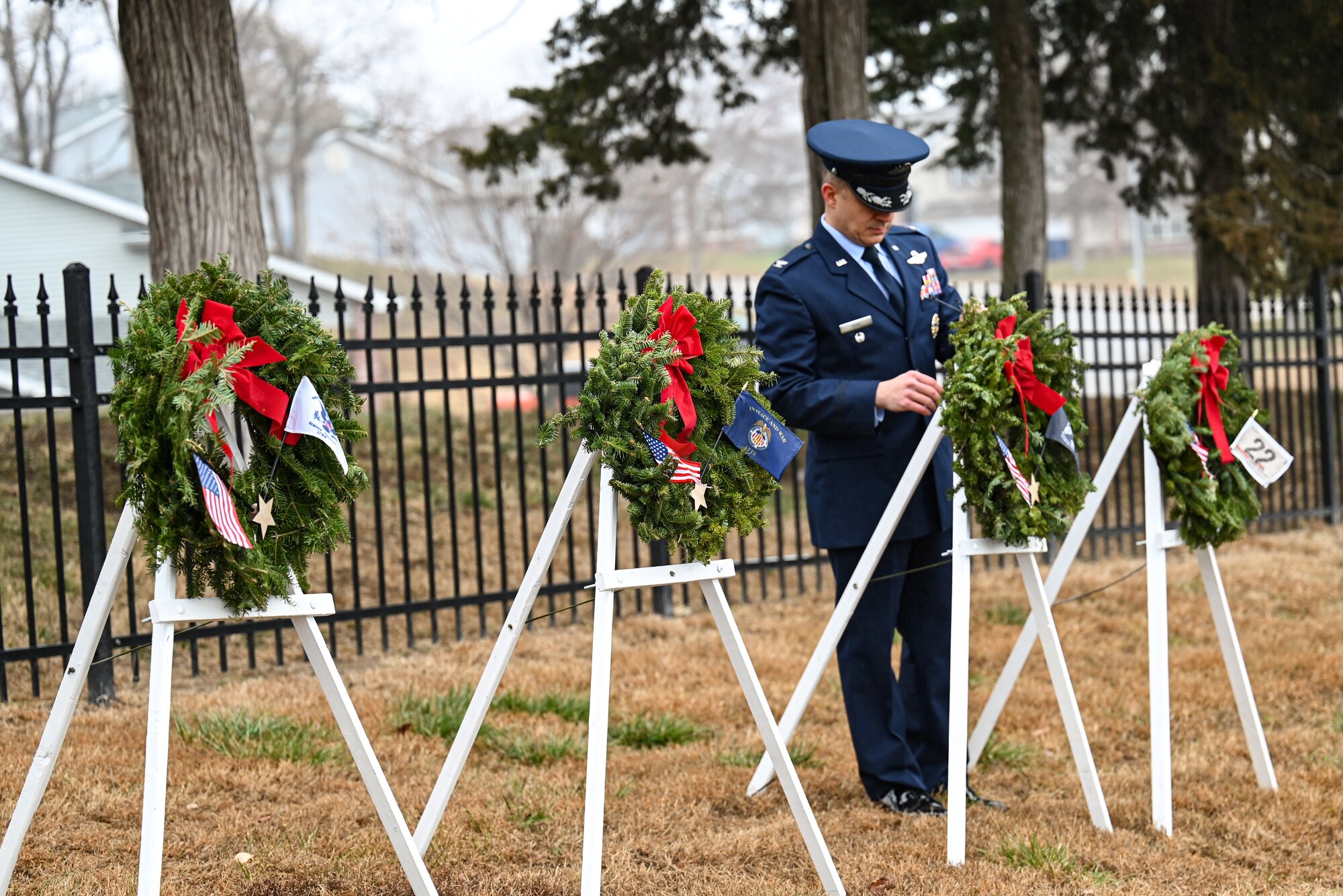 Man adjusts a wreath