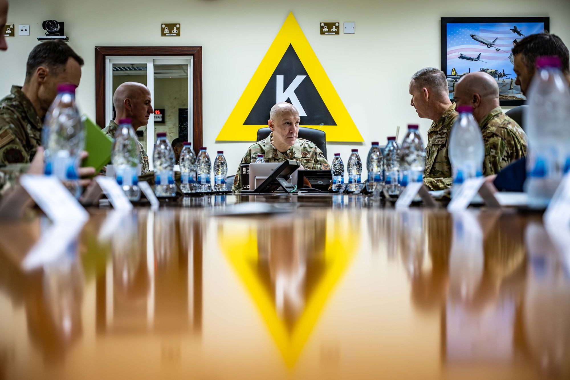 Leadership of the 379th Air Expeditionary Wing brief U.S. Air Force Chief of Staff Gen. David Allvin, center, and Chief Master Sgt. of the Air Force David Flosi.