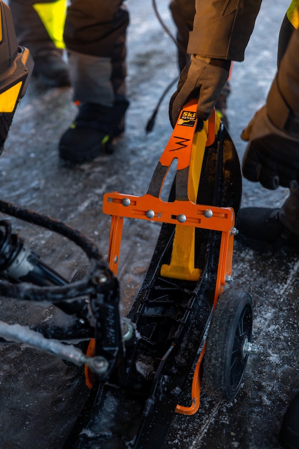 U.S. Marine Corps 1st Sgt. Robert Votta attaches a ski-saver to the skis of a snowmobile prior to loading the vehicle onto a KC-130J Super Hercules in Kotzebue, Alaska, Dec. 13, 2024. Votta, first sergeant of Detachment Delta Company, 4th Law Enforcement Battalion, Force Headquarters Group, Marine Forces Reserve, assisted by Marines with Marine Aerial Refueler Transport Squadron 153, Marine Aircraft Group 24, 1st Marine Aircraft Wing, joined by Airmen flew from Kotzebue to Utqiagvik, Alaska to continue this year’s Toys for Tots operation. The Toys for Tots mission exemplifies the Marine Corps spirit in the Last Frontier, strengthening community ties while sharpening the Marines' readiness for Arctic operations. (U.S. Marine Corps photo by Sgt. Ethan M. LeBlanc)