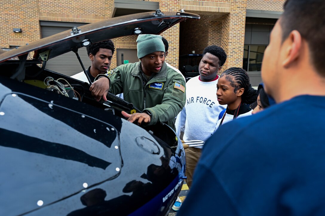People gather around the hood of a helicopter