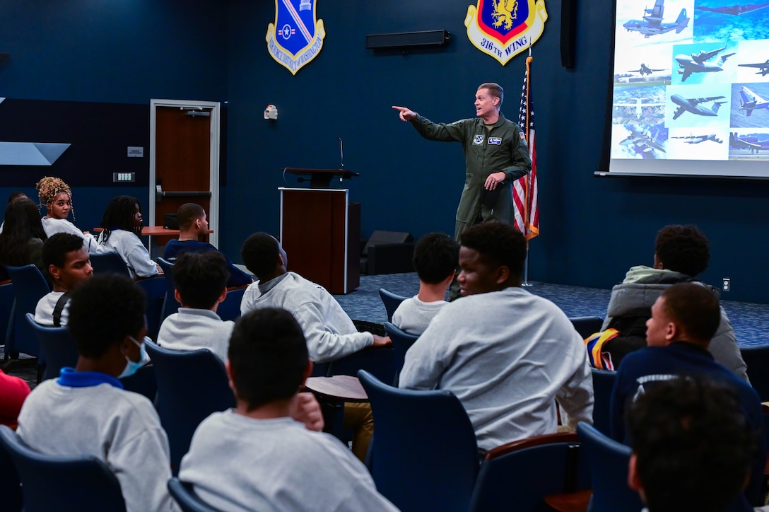 A U.S. Airman stands in front of an audience