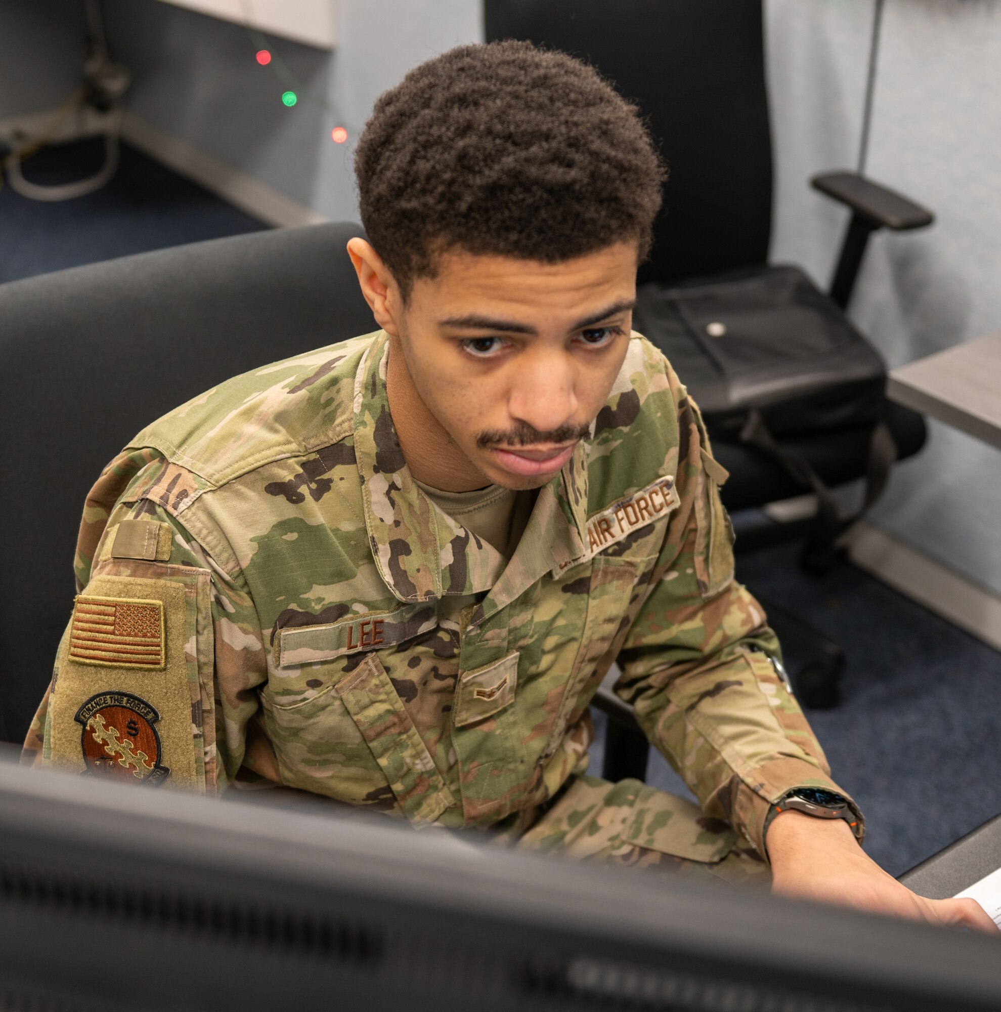 Image of Airman sitting at computer.