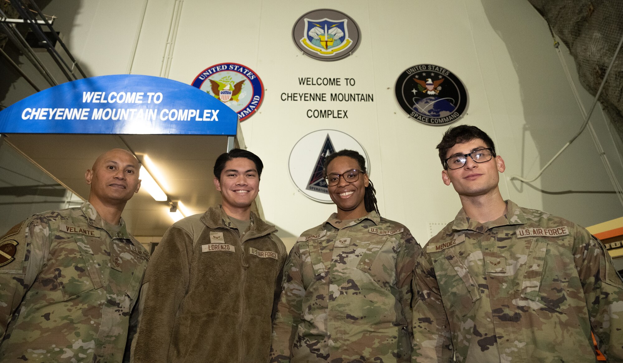 Service member pose in front of the Cheyenne Mountain Complex entrance shoulder to shoulder.