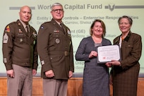 Caral E. Spangler, Assistant Secretary of the Army for Financial Management and Comptroller, along with Lt. Gen. Paul A. Chamberlain, Military Deputy to the ASA (FM&C), and Sgt. Maj. Terry L. Anderson, ASA (FM&C) senior enlisted advisor, present Kathryn VanScoy, U.S. Army Materiel Command Audit Readiness Division chief, with a certificate of appreciation during the Army’s Annual Audit Summit at the Mark Center in Alexandria, Virginia, Dec. 10, 2024. VanScoy’s and her team’s efforts helped the Army downgrade a Working Capital Fund material weakness in Fiscal Year 2024. (U.S. Army photo by Mark R. W. Orders-Woempner)