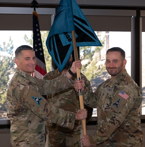 U.S. Space Force Lt. Col. Brandon Wilson, right, accepts the guidon for the 33rd Range Squadron from U.S. Space Force Col. Jay Steingold, Delta 11 commander, during an assumption of command ceremony at Schriever Space Force Base, Colorado, December 16, 2024.