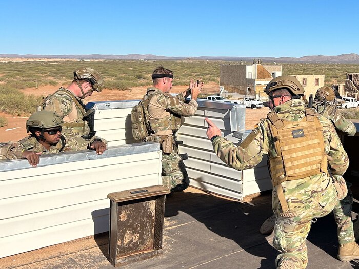 U.S. Air Force Master Sgt. Robert Tatum, center, 42nd Medical Group pharmacy flight chief, communicates with U.S. Air Force Staff Sgt. Jayce Pickens, far left, Air Force Life Cycle Management Center, Gunter Business Operations non-commissioned officer in charge of development operations, observing incoming contact Fort Bliss, Texas Nov. 14, 2024.