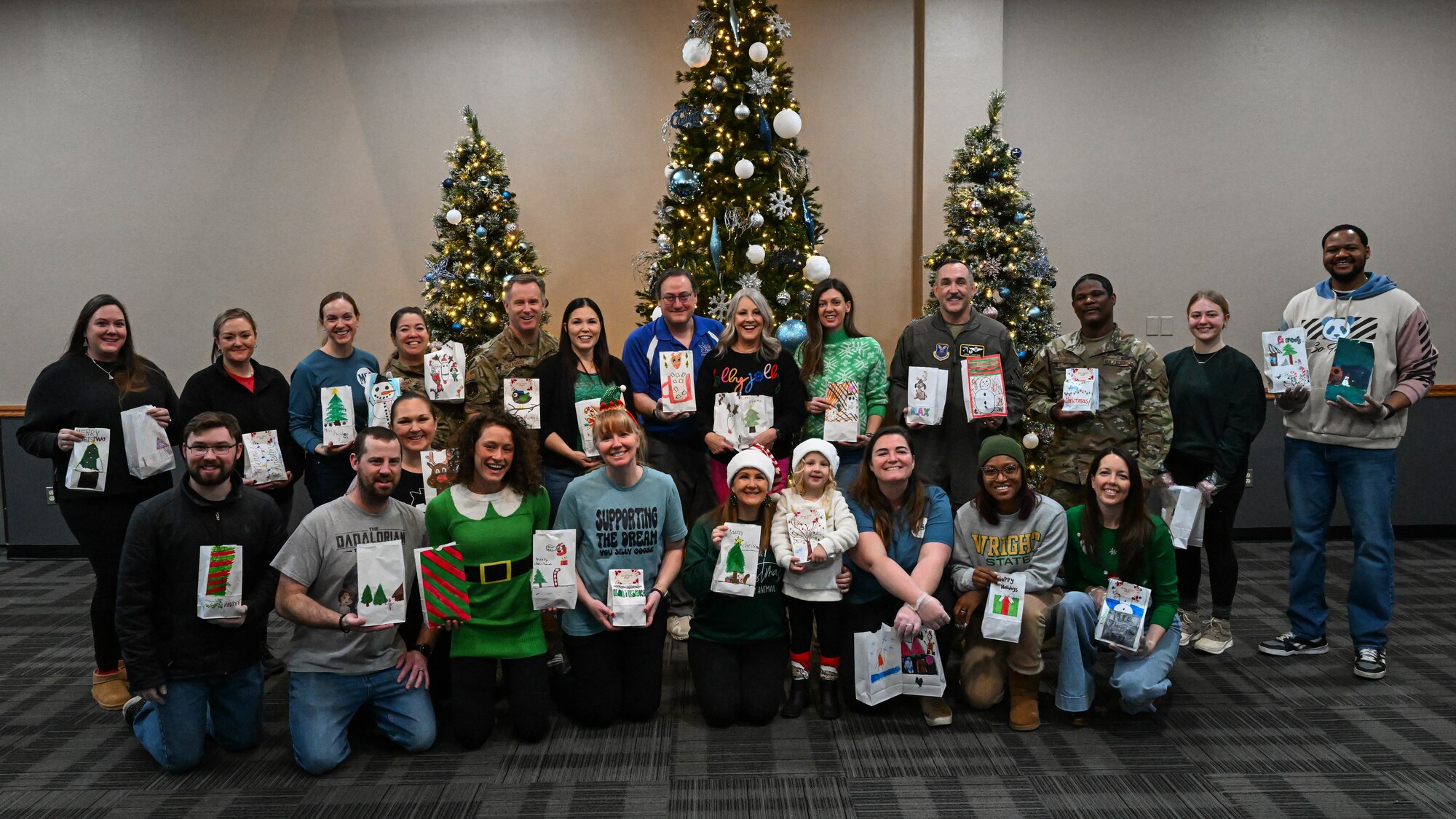 Members of the Minot community, Team Minot leaders, and family members pose for a photo during the Cookie Drive at Minot Air Force Base, North Dakota, Dec. 19, 2024. As part of the Cookie Drive, members of the Minot community, Team Minot leaders, and family members baked and delivered cookies to Airman around Minot AFB. (U.S. Air Force photo by Senior Airman Kyle Wilson)