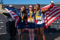 Ret. Army Cpl. Tiffanie Johnson (R) with Army Spc Angela Sutton and Marine Lance Cpl Annika Hutsler (L)  during a medal ceremony at the 2023 Invictus Games