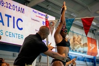 Team Army coach Atiba Wade, left, gives instructions to U.S. Army Cpl. Tiffany Johnson during swim practice at the 2022 Department of Defense Warrior Games