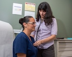 Female doctor examines patient with stethoscope