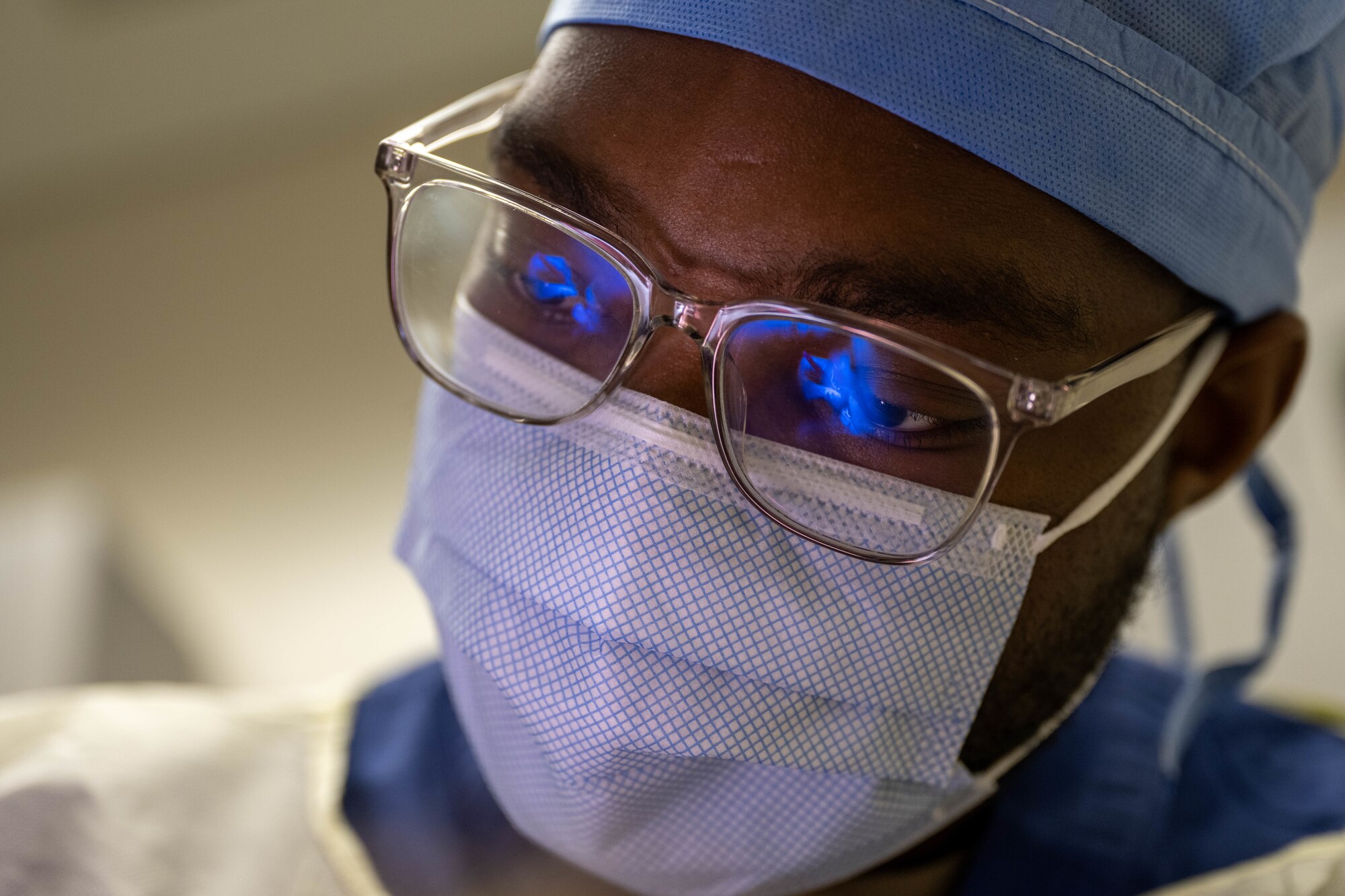A dental assistant wearing clear glasses examines a patient's teeth on Joint Base Pearl Harbor-Hickam, Hawaii.