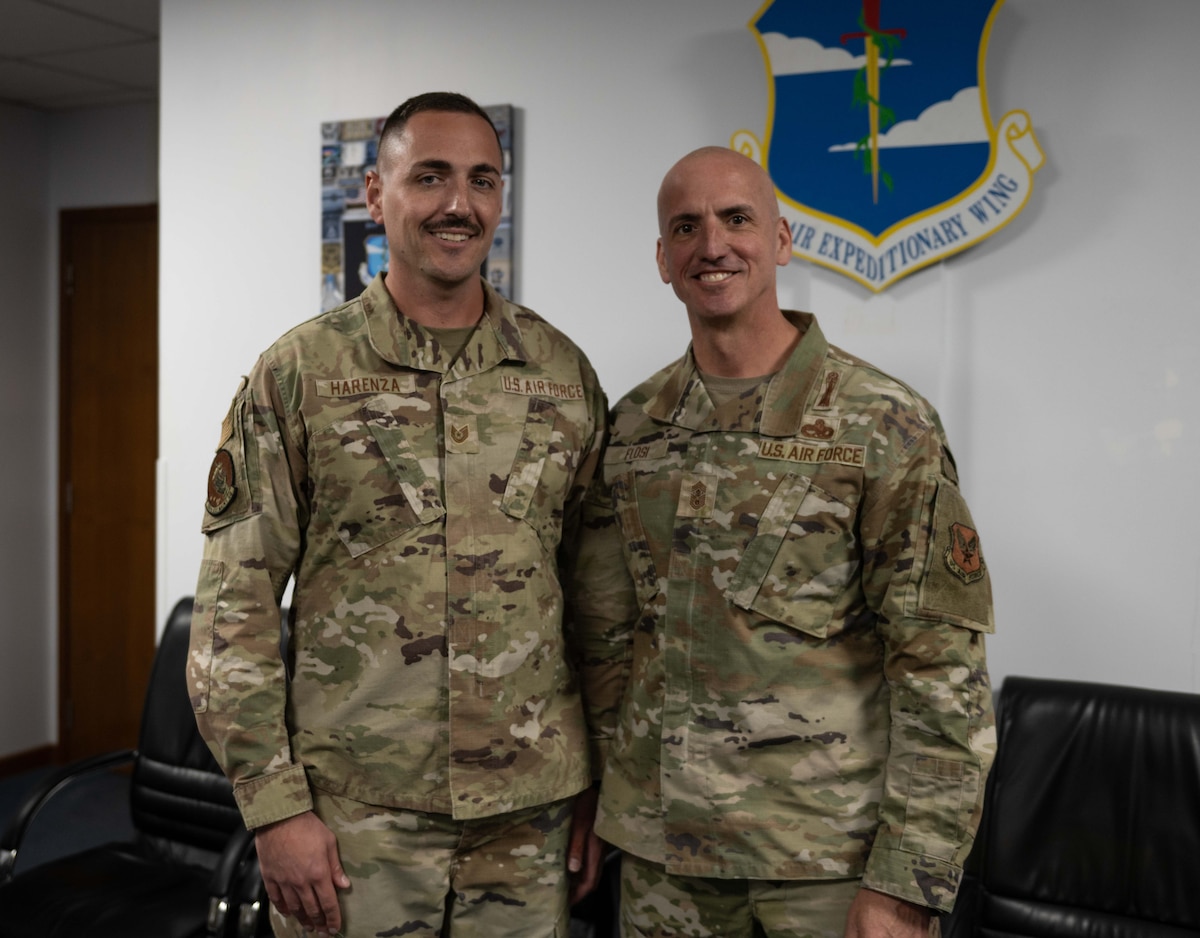 Chief Master Sgt. of the Air Force David Flosi poses for a photo after coining a U.S. Air Force ammo production Airman.