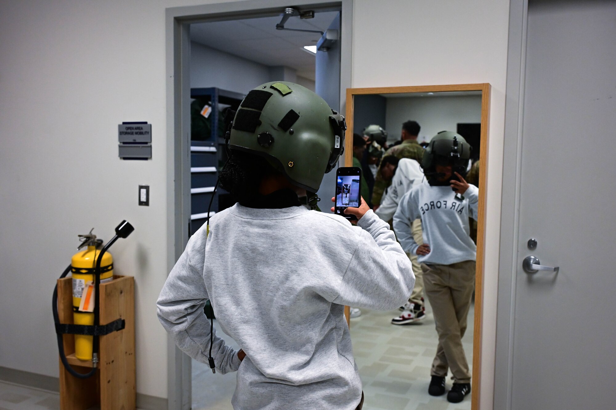 A teenager takes a selfie while wearing an aviation helmet