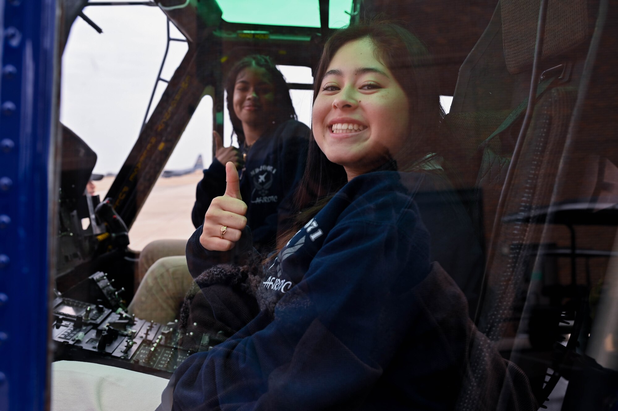 Two teenage girls give a thumbs up