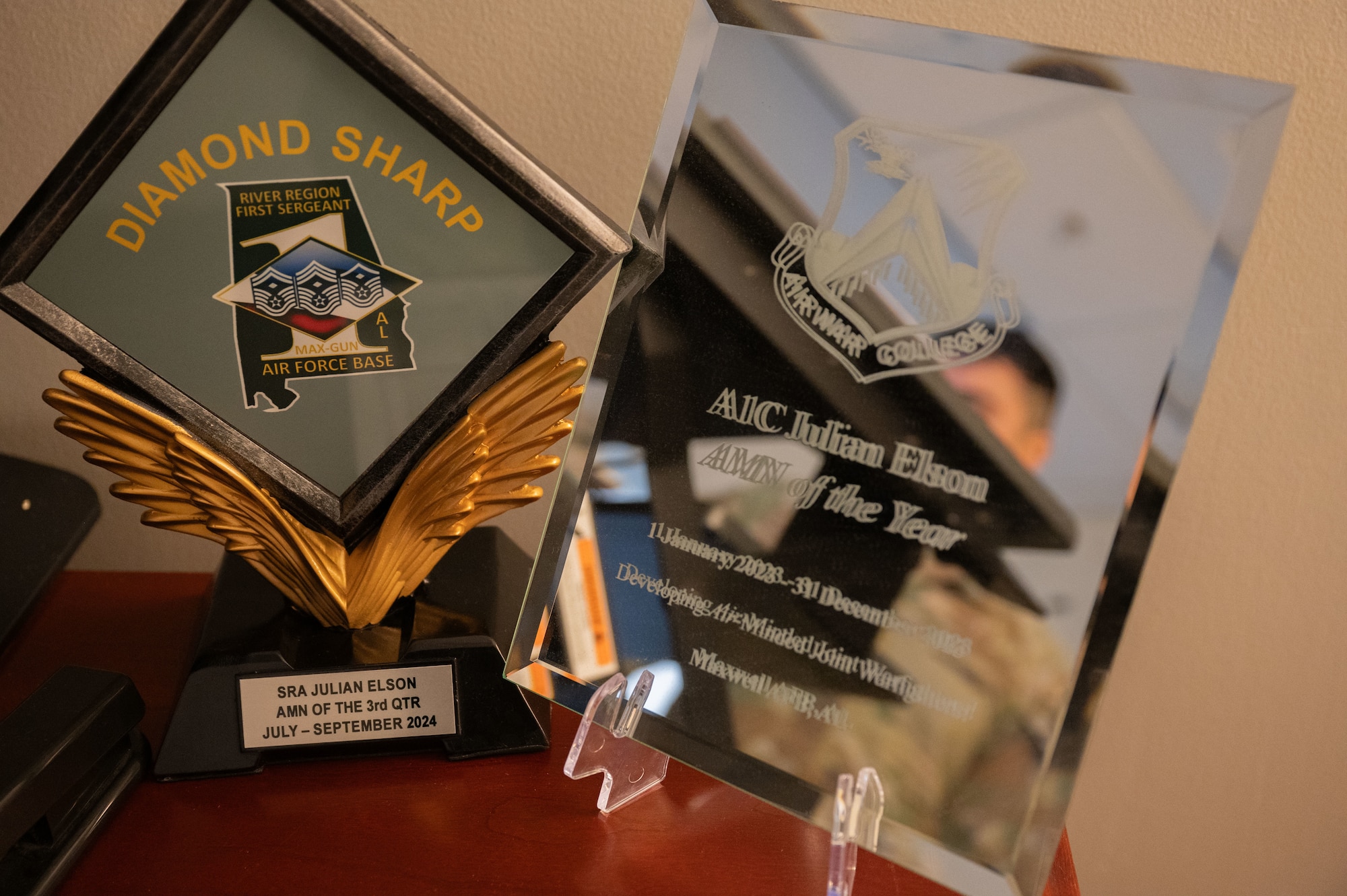 The Diamon Sharp Award and an Airman of the Year award for Senior Airman Julian Elson, Air War College executive services admin, is displayed on his desk at Maxwell Air Force Base, Alabama, Nov. 13, 2024. Elson was recently awarded with the Diamond Sharp Award for the third quarter of 2024. The Diamond Sharp Award goes to individuals who display one of these qualities: actions of a first sergeant (caring for Airmen/Guardians), outstanding performance, impeccable military bearing and dress and appearance.