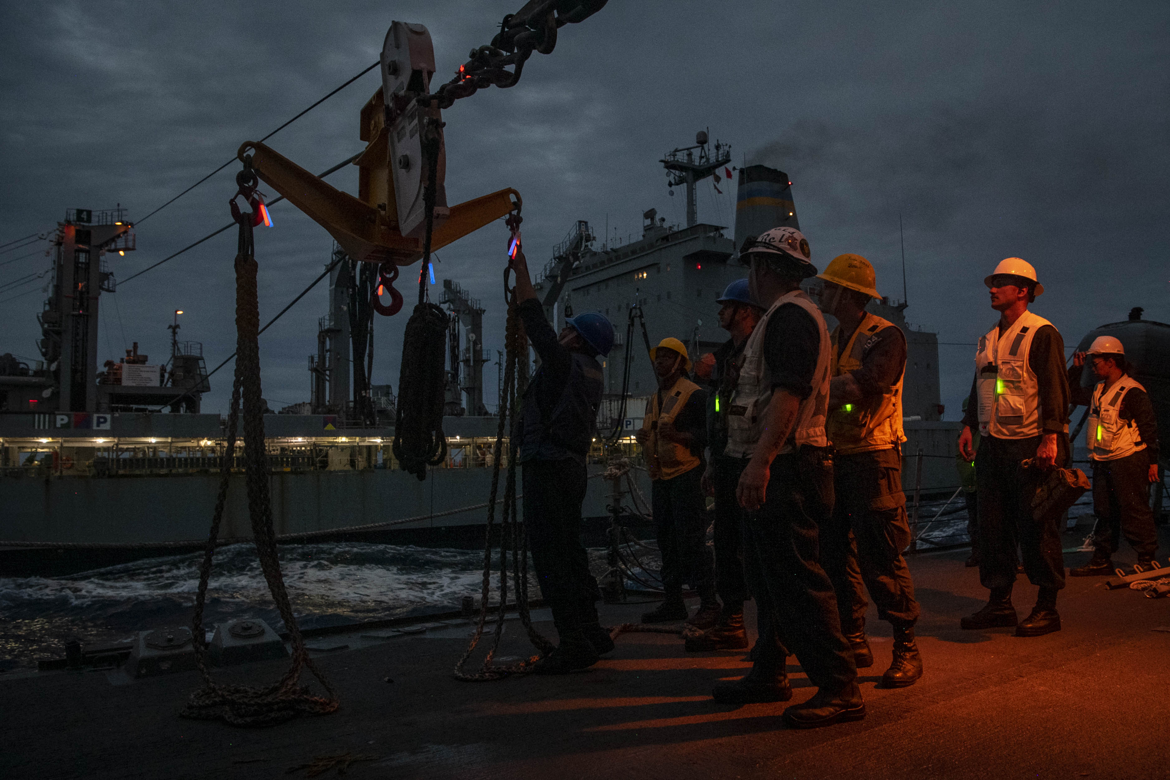 Boatswain’s Mate 2nd Class Keith Avinger, of Chino, Calif., left, prepares to send back empty pallets to the fleet replenishment oiler USNS Henry J. Kaiser (T-AO 187) aboard the Arleigh Burke-class guided-missile destroyer USS Sterett (DDG 104) during a replenishment at sea, Dec. 18, 2024.